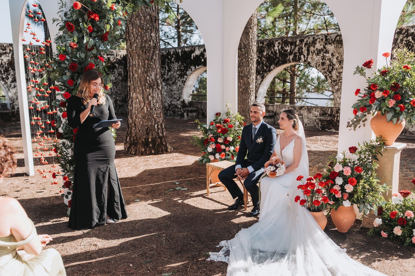 Ceremonia civil en una finca de Gran Canaria con arcos de piedra y flores rojas